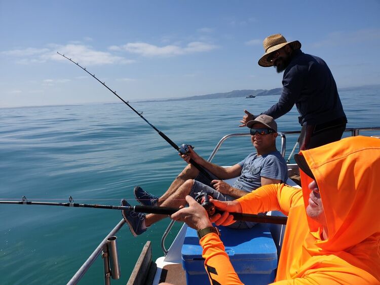 Group fishing off a boat on calm water