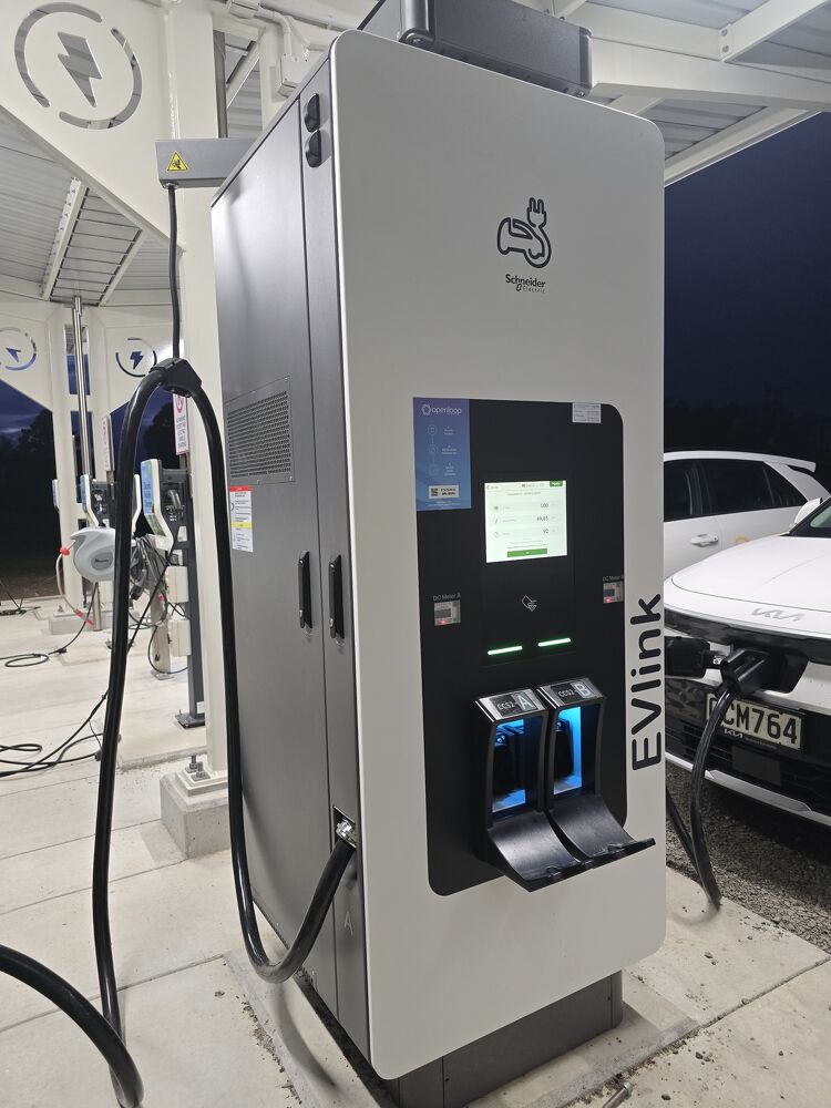 EV charging station with two vehicles plugged in at night